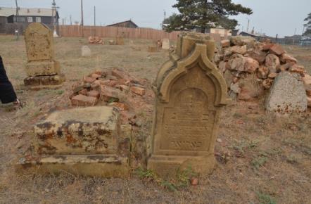 A similar pyramidal tombstone topped with a cross is found in