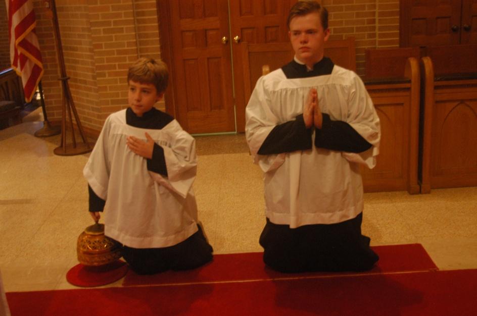 If one altar boy is serving the towel is spread out and laid on the left forearm holding the water cruet in the left hand and the bowl in