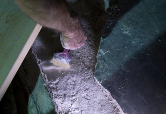 View Images Left: A restorer removes debris beneath a broken marble slab to expose the original rock surface of what is considered the burial place of Jesus.