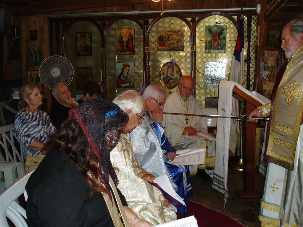 3. Metropolitan Archbishop + Haralambos uses a sword to start the investitures. He is putting the sword on Fr.