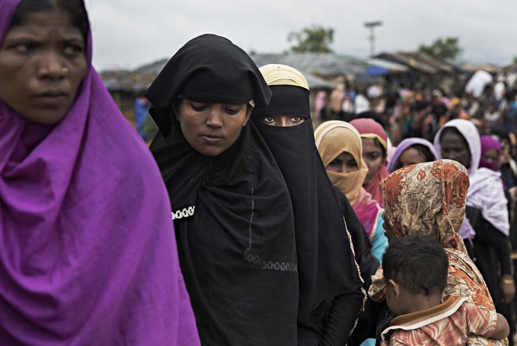 Rohingya refugees wait in a food distribution line in Kutapalong refugee camp, Cox s Bazar, Bangladesh, on October 12, 2017. Photo by Andre Malerba women three times.