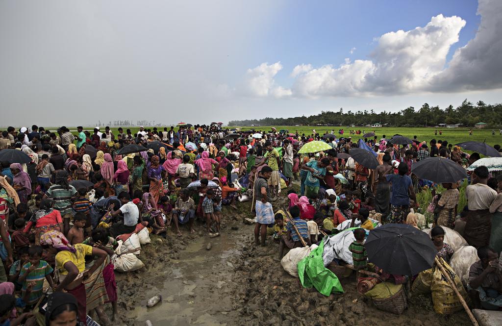 Rohingya refugees wait in a muddy rice paddy on orders of the Border Guards Bangladesh (BGB) after crossing the Naf River from Myanmar to Anjumanpara, Bangladesh, on October 16, 2017.