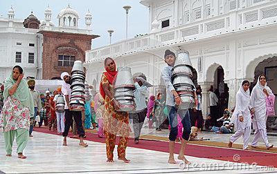 (Sikh men, women and children helping carry utensils to serve food) 3.