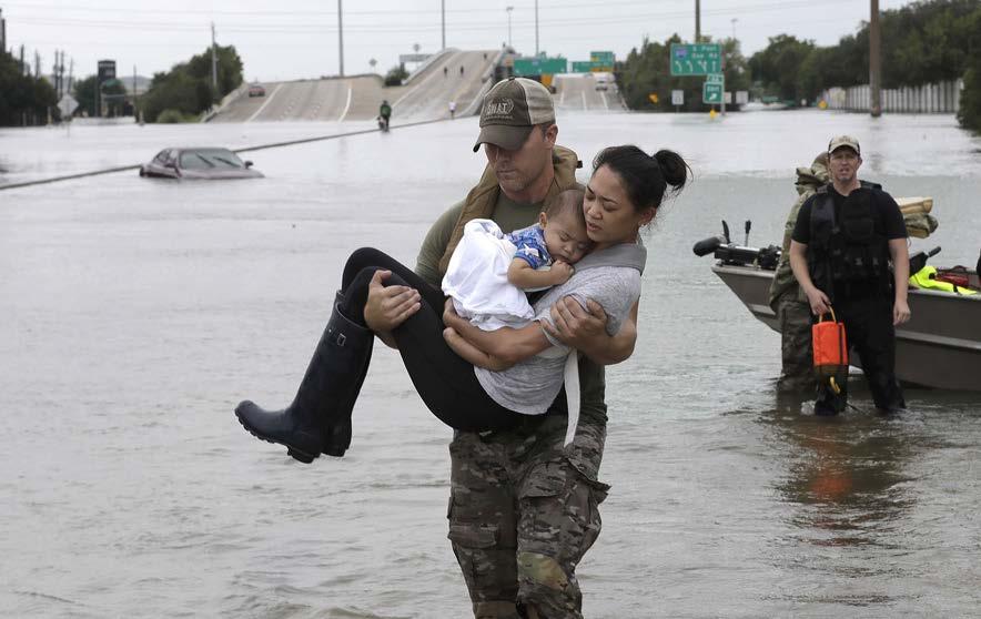 named Connie Pham in his arms through the flood. In her arms she is holding her 13 month old baby Aiden.