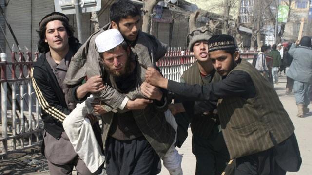THE QURAN Afghan Protesters Hurl Grenades at US Base Afghans carry a wounded man during an anti-u.s. demonstration in Kunduz, north of Kabul, Afghanistan, Saturday, Feb.