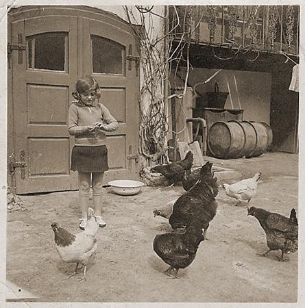 Photograph 12: Ruth Wottitzky (26120) This image shows Ruth feeding chickens outside her home. Ruth was born in Austria, where her family had a general store.