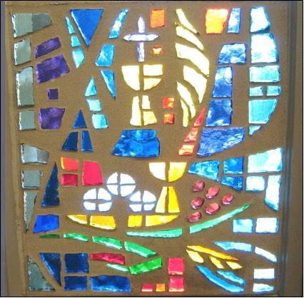 WINDOW SIX is devoted to the Passion of our Lord and His Resurrection. Beginning at the bottom we see loaves of bread and a chalice.
