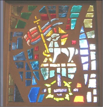 At the top of this window, we see Jesus, the Lamb of God emerging from the empty tomb.
