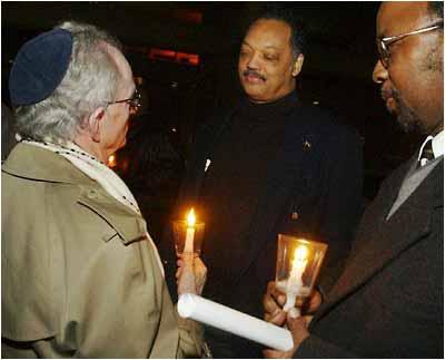 The Rev. Jesse Jackson, center, talks to Rabbi Hillel Cohn, left, before Jackson goes up on stage to speak to protesters, Tuesday night, Feb. 3, 2004, at Riverside City Hall, in Riverside, Calif.