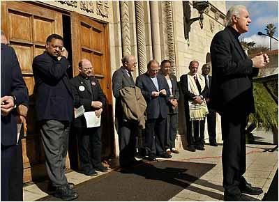 Cordova) Actor Mike Farrell, right, addresses a group of protesters as Rev. Jesse Jackson, left, and other religious and community leaders listen Tuesday, Feb.