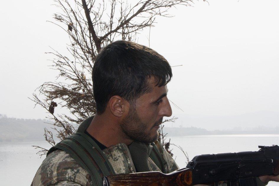 A fighter of the Shams al-shamal militia at a front line position at Ja'ada, on the east bank of the Euphrates.