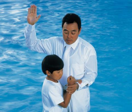 The child is being baptized by immersion (being completely covered by