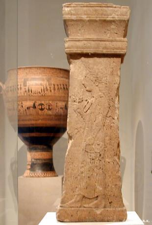 216 Fig. 32. East-Greek, C. 550-525. Carved limestone pillar with woman carrying a lotus in her hand on one side with two tiny winged youths with wreaths hovering above her head.
