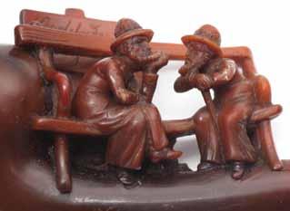 Carved Bakelite; carved wood; amber mouthpiece. In the center of the pipe is an engraving of two Jews sitting on a bench.