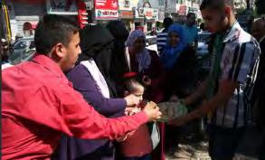 Left: Hamas activist in Gaza Strip hands out candy to passersby to celebrate the signing of the reconciliation agreement in Cairo (Palinfo Twitter account, October 12, 2017).