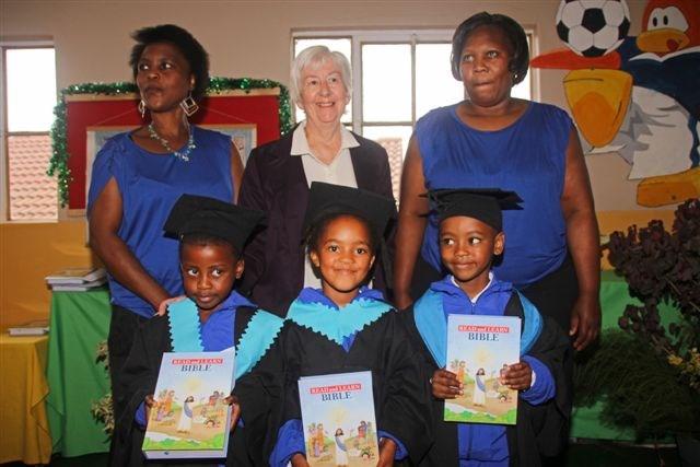 Top Photo Left to Right: Thoko, Polly, Kate and Gwyn distribute Bibles as Monica, deputy principal, watches as each child receives one.