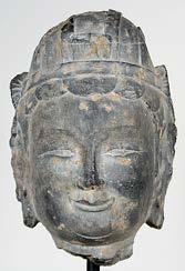 What characteristics does the bodhisattva figure have that distinguish it from the sculpture heads? How did the artist who carved the bodhisattva create a sense of calm, power, and compassion?