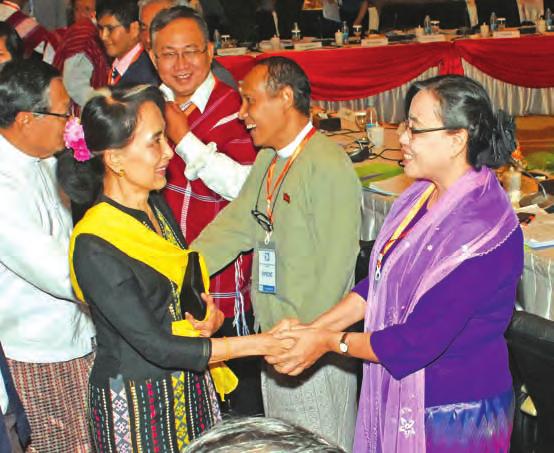 Daw Aung San Suu Kyi, left, shakes hands with Daw Saw Mya Yazar Lin of the Arakan Liberation Party.