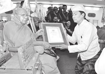 and Saddhamma Jotikadhaja title and certificate on U Kyaw Wai of Chanayethazan Township of Mandalay President U Thein Sein, wife Daw Khin Khin Win present rice and offertories to members of Sangha.
