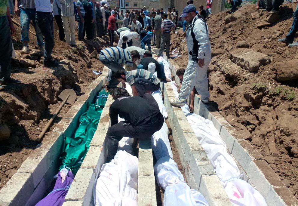 (Joseph Eid/AFP/Getty Images) # People gather at a mass burial for the victims purportedly killed