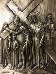 V. Fifth Station - The Cross is laid on Simon of Cyrene As they led Jesus away, they came upon a man of Cyrene, Simon by name, who was coming in from the country, and laid on him the cross to carry
