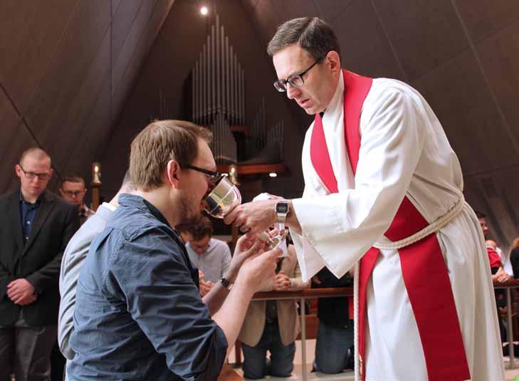 Rev. Mark Sheafer assists with Communion as the CTSFW community gathers around Word and Sacrament in Kramer Chapel.