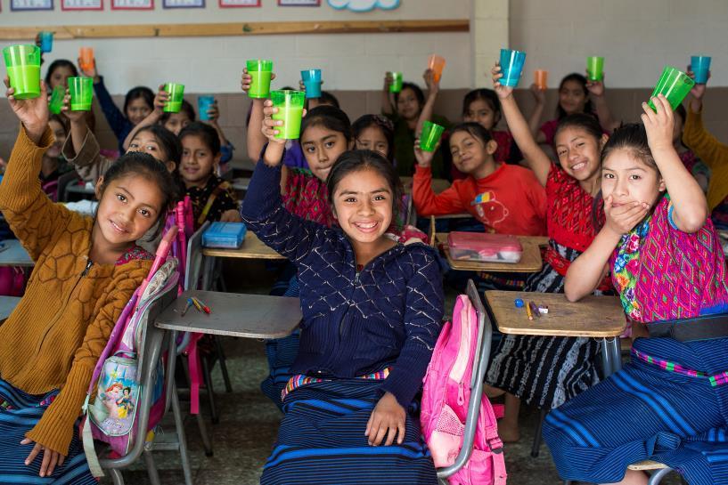 Rotary Around the World Third graders drink soy milk at Proximos Pasos school in Guatemala.