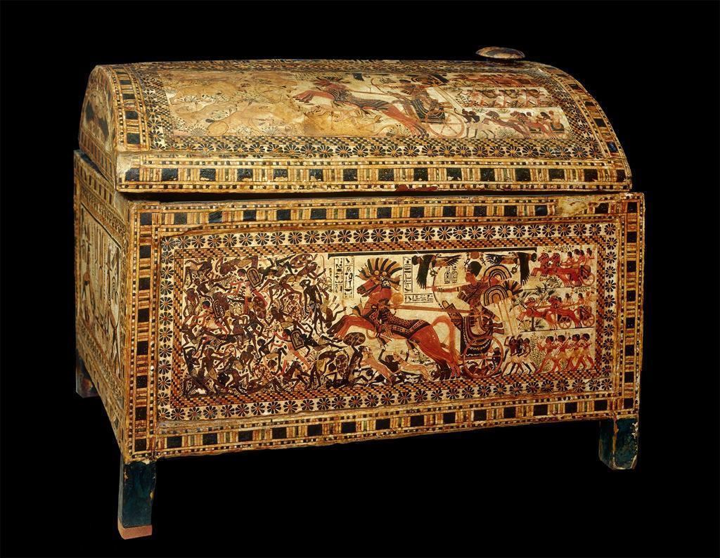 In this painted chest, the subject of a pharaoh riding a war chariot, drawing his bow, is