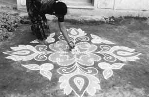 figure 2 Adorning a kolam diagram, Madurai, Tamil Nadu. Photo by Stephen Huyler. Mariamman every day in his household shrine, on Tuesdays he chooses to go to the temple.