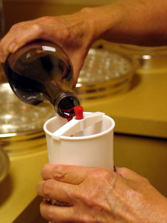 Select a tray and starting from the outside ring working towards the center, partially fill the individual cups with the consecrated (blessed) wine.