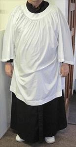 Surplice A white cover garment, generally longer than a cotta, worn over a black cassock by acolytes during Eucharistic