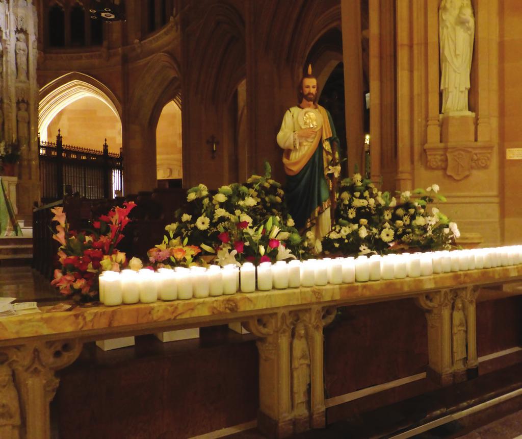 February St. Jude gazes upon a loving offering of flowers and candles for the 10th Annual St. Jude Pilgrimage.