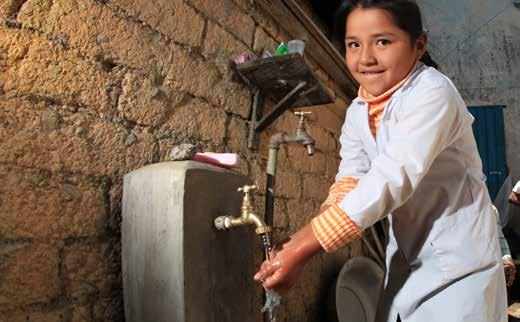 Neisa Challco washes her hads with the family`s ew faucet, which brigs water from a water system costructed by a CRS-fuded project i Bolivia.
