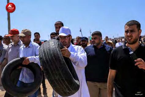 8 Senior Hamas figure Fathi Hamad carries a tire on his way to the "return camp" in eastern Jabalia (Facebook