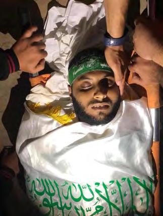 Left: His body was wrapped in a Hamas flag and he was wearing a Hamas military wing headband for burial (Facebook page of
