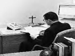 Father O Callaghan catches up on some desk work in his office at the Loyola University Medical Center. would look it over and mail it.