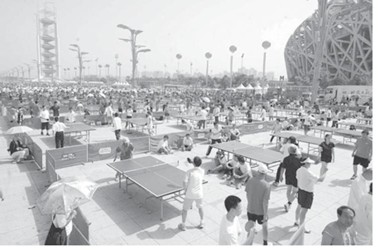 People play table tennis during the opening ceremony for the 7th National Fitness Festival of Beijing held next to the National Stadium, also known as the Bird s Nest, in Beijing, China, June 20,