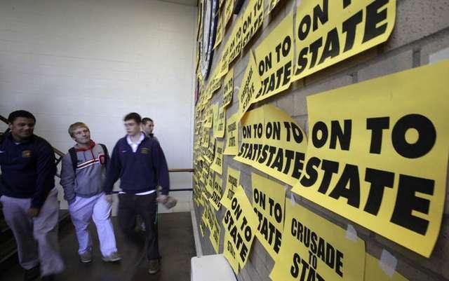 Students at Archbishop Moeller High School pass by a wall celebrating their football teams bid for the State title Saturday against Toledo