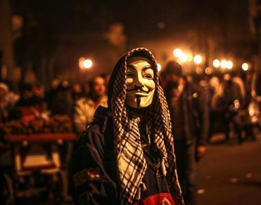 A protester wears a Guy Fawkes mask in Tahrir square in