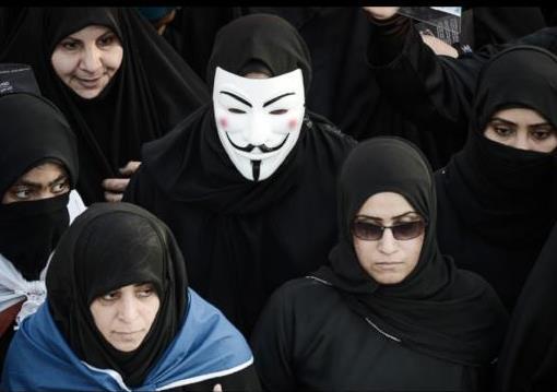 A Bahraini woman wears a Guy Fawkes mask