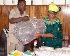 Mama Maria Nyerere, widow of President Nyerere, receiving blankets for orphaned children in the village of