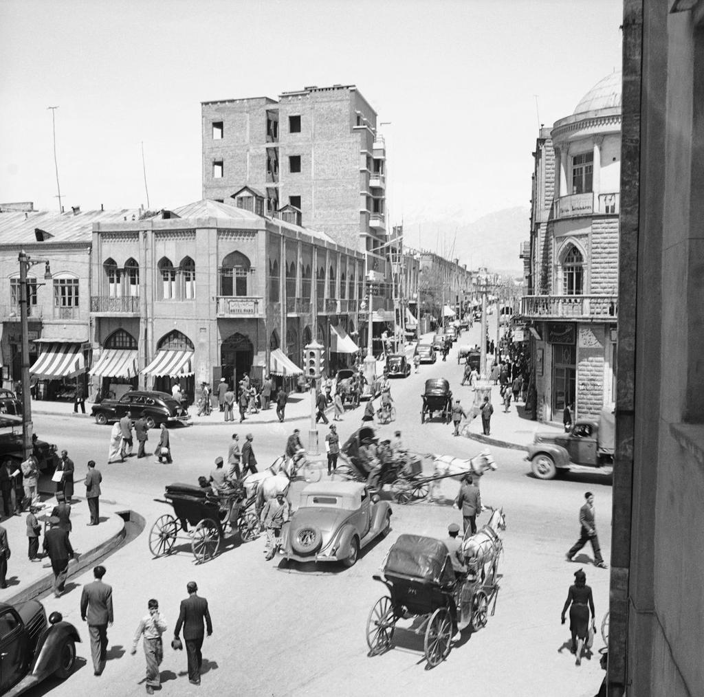 Pedestrians and cars travel through the main intersection of Tehran, Iran, April 20,1946.