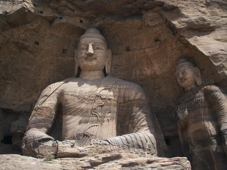The largest figure is nearly 14 meters high and was once protected by a multi-story wooden façade.