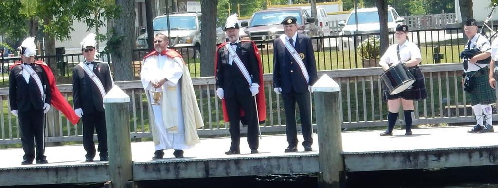the Blessing). Msgr. Reed with the Assembly Color Guard, local bagpipers, and Capt. Boot of the Blackwater Pyrates and his wife. Msgr. Reed with the Color Guard and bagpipers waiting for the parade of boats to pass by.