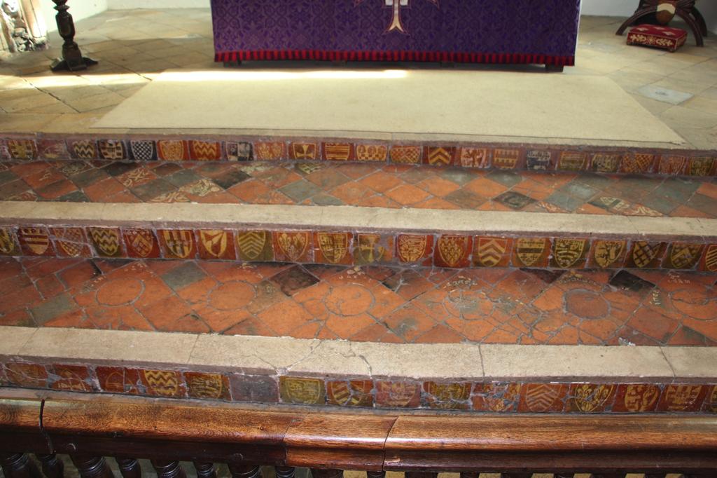 Tiles with heraldic shields face the sanctuary steps at St
