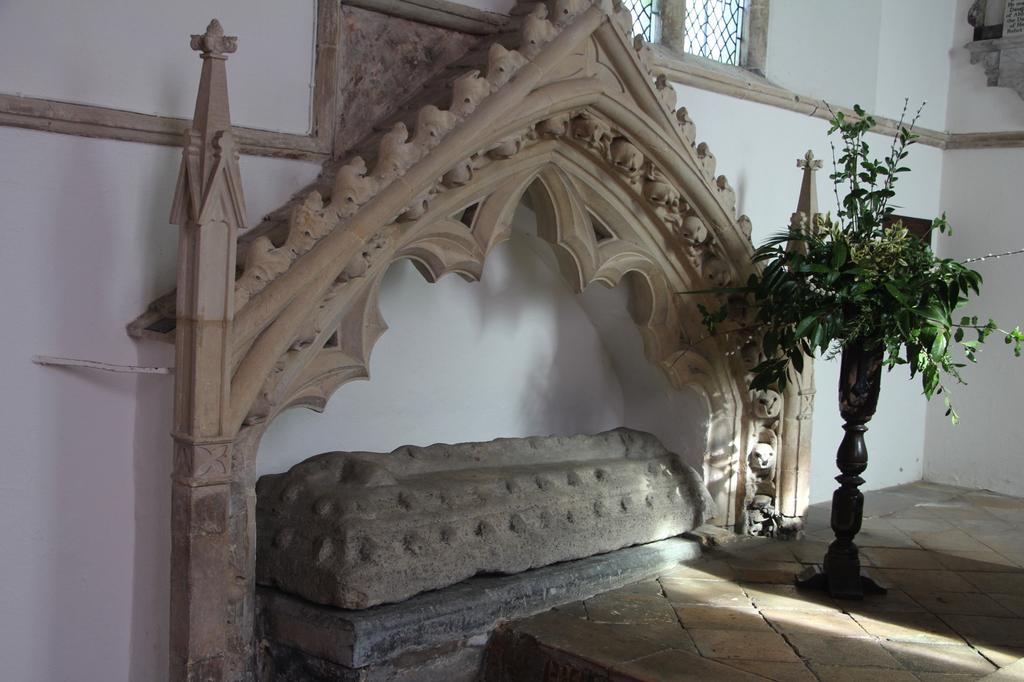 The Easter sepulchre at St Giles, Bredon. This is an early wall tomb set under a pinnacled ogee arch. The simple hog back tomb slab is covered with ball decorations.