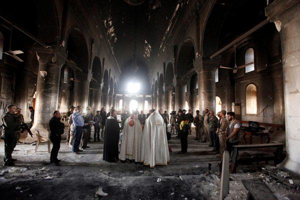 Alaa Al-Marjani / Reuters Iraqi priests hold the first mass in the damaged