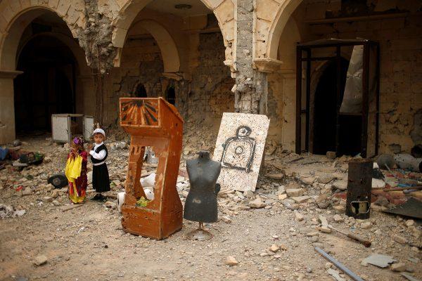 Suhaib Salem / Reuters Boys visit the burnt out main church as Iraqis attend the