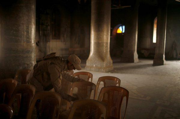 Suhaib Salem / Reuters An Iraqi soldier cleans chairs as others attend the first Palm Sunday procession in the