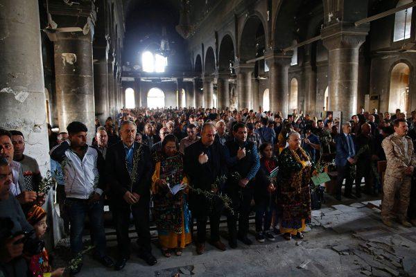 Ahmad Gharabli / AFP / Getty Iraqi Christian residents of Qaraqosh attend the first Palm Sunday service at the